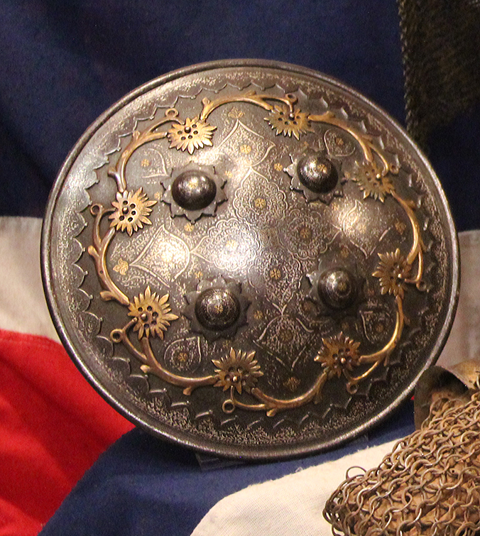 A Gold Inlaid Traditional Persian Armour Suite, of Helmet, Shield & Arm Defence. The Kulah Khud,(کلاهخود) Sipar (سپر), and Bazu Band (بازوبند). Late 18th to Early 19th Century, Possibly Wootz Steel { Pulad}