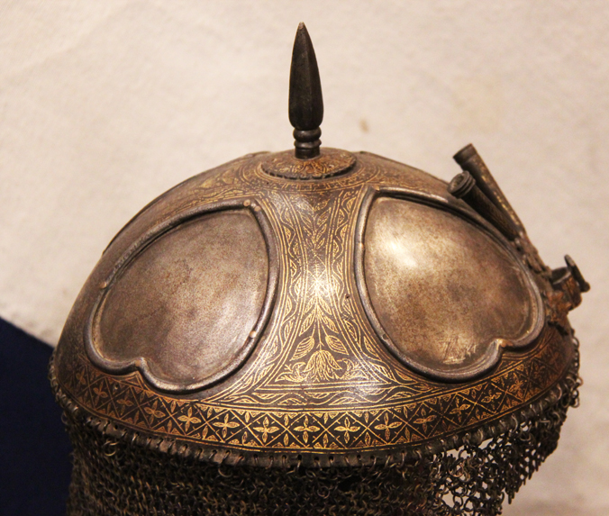 A Gold Inlaid Traditional Persian Armour Suite, of Helmet, Shield & Arm Defence. The Kulah Khud,(کلاهخود) Sipar (سپر), and Bazu Band (بازوبند). Late 18th to Early 19th Century, Possibly Wootz Steel { Pulad}