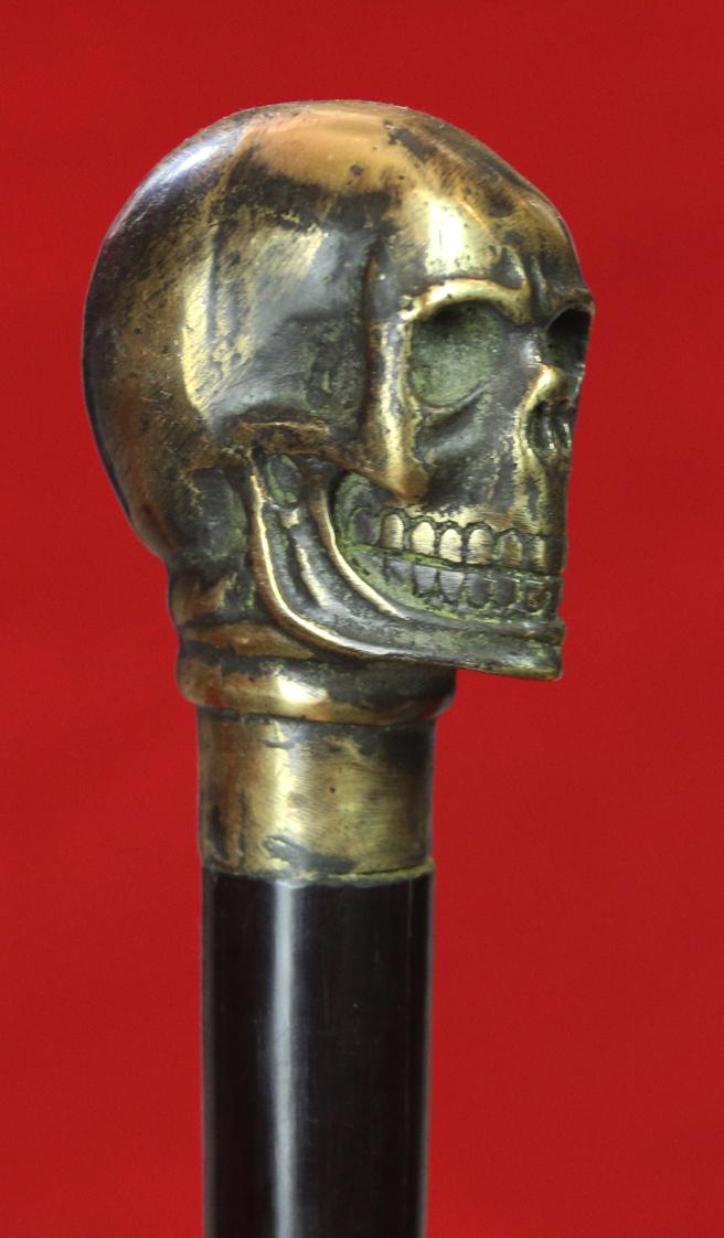 An Imposing & Elegant ‘Morituri’ Walking Cane Combination ‘Bartitsu’ Club Stick, Cast Bronze Skull With & Sophisticated Ebony Stick & Carved Bone Ferrul. Once A Most Essential Accessory For the Gentleman About Town.