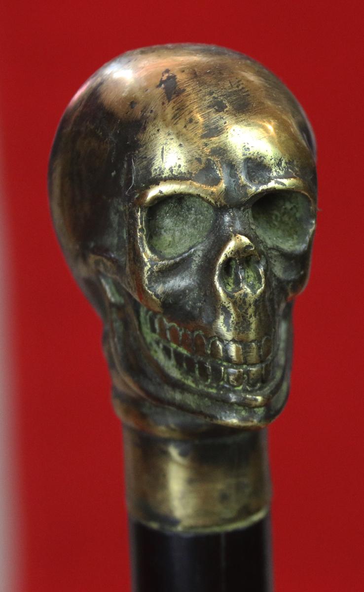 An Imposing & Elegant ‘Morituri’ Walking Cane Combination ‘Bartitsu’ Club Stick, Cast Bronze Skull With & Sophisticated Ebony Stick & Carved Bone Ferrul. Once A Most Essential Accessory For the Gentleman About Town.
