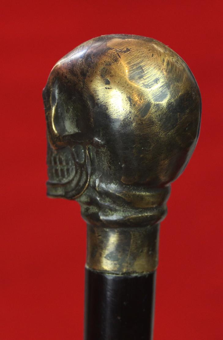 An Imposing & Elegant ‘Morituri’ Walking Cane Combination ‘Bartitsu’ Club Stick, Cast Bronze Skull With & Sophisticated Ebony Stick & Carved Bone Ferrul. Once A Most Essential Accessory For the Gentleman About Town.