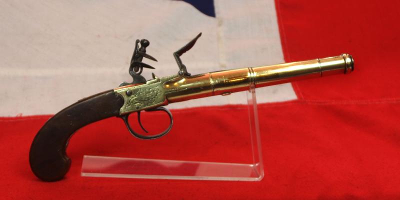 A Stunning Mid 18th Century Ship's Captain Brass Cannon Barrel Pistol with a Silver Escutchon of the Goddess Minerva Adorned With Her Dolphin Helmet & Fishscale Armour