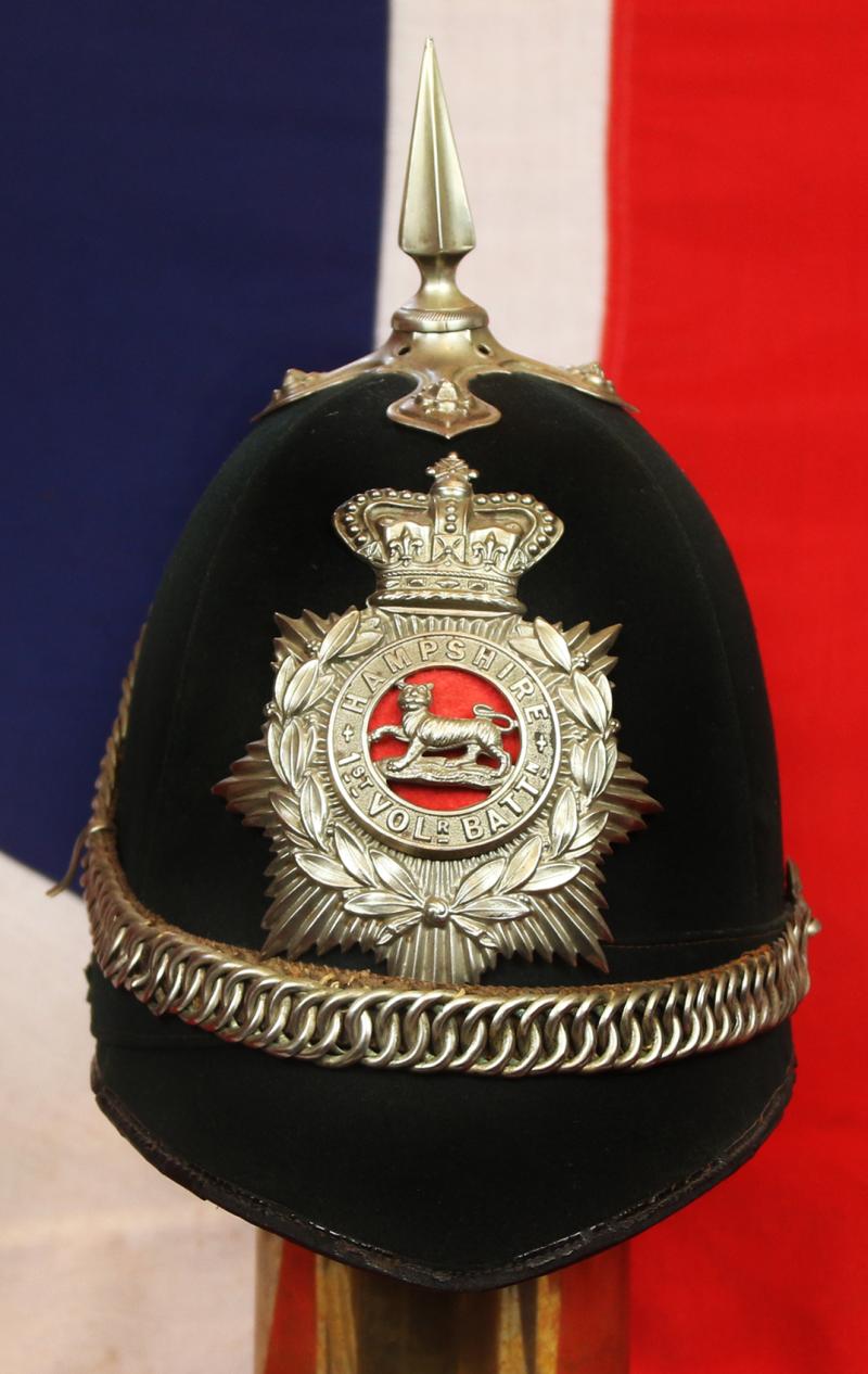 A Superb Victorian Service Helmet of the Hampshire Regiment, the Ist Volunteer Battalion. Blue Cloth with Silver Badge, Fittings, Spike, & Rose Head Curb Chain Mounts and Chin Chain