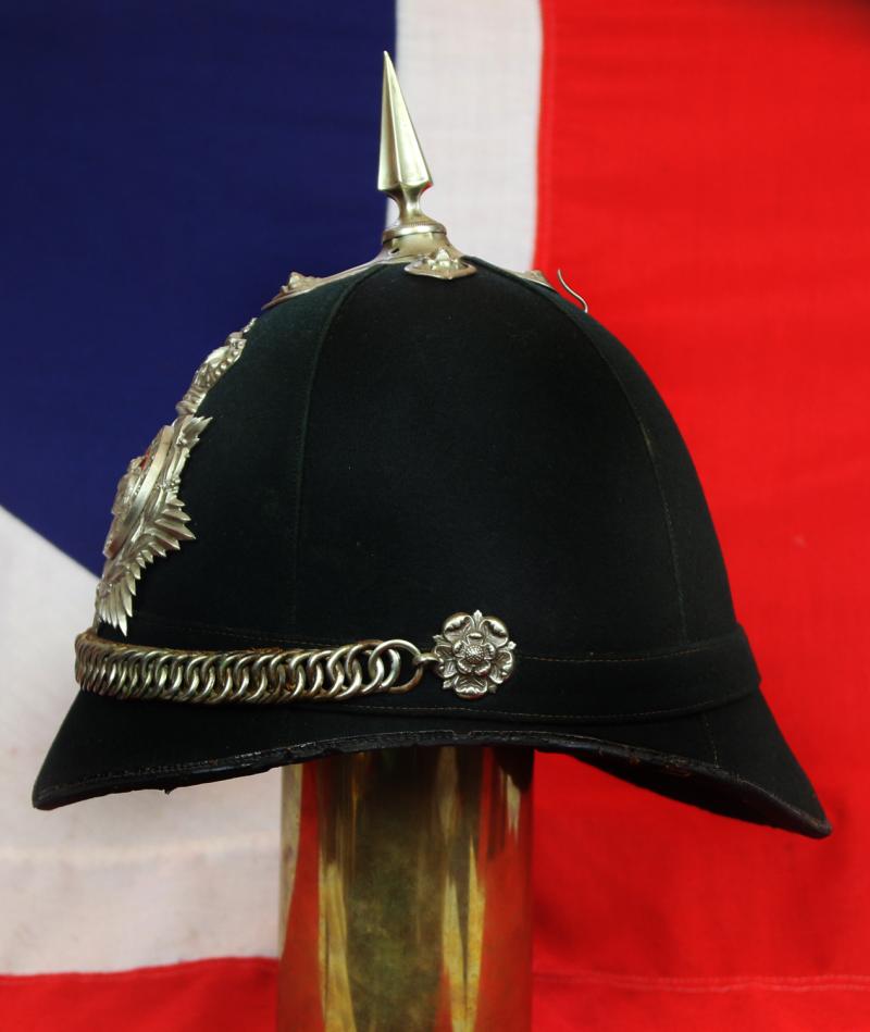A Superb Victorian Service Helmet of the Hampshire Regiment, the Ist Volunteer Battalion. Blue Cloth with Silver Badge, Fittings, Spike, & Rose Head Curb Chain Mounts and Chin Chain
