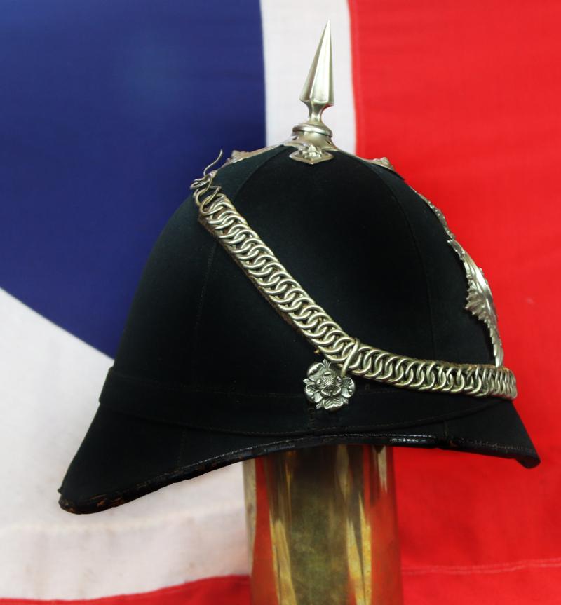 A Superb Victorian Service Helmet of the Hampshire Regiment, the Ist Volunteer Battalion. Blue Cloth with Silver Badge, Fittings, Spike, & Rose Head Curb Chain Mounts and Chin Chain