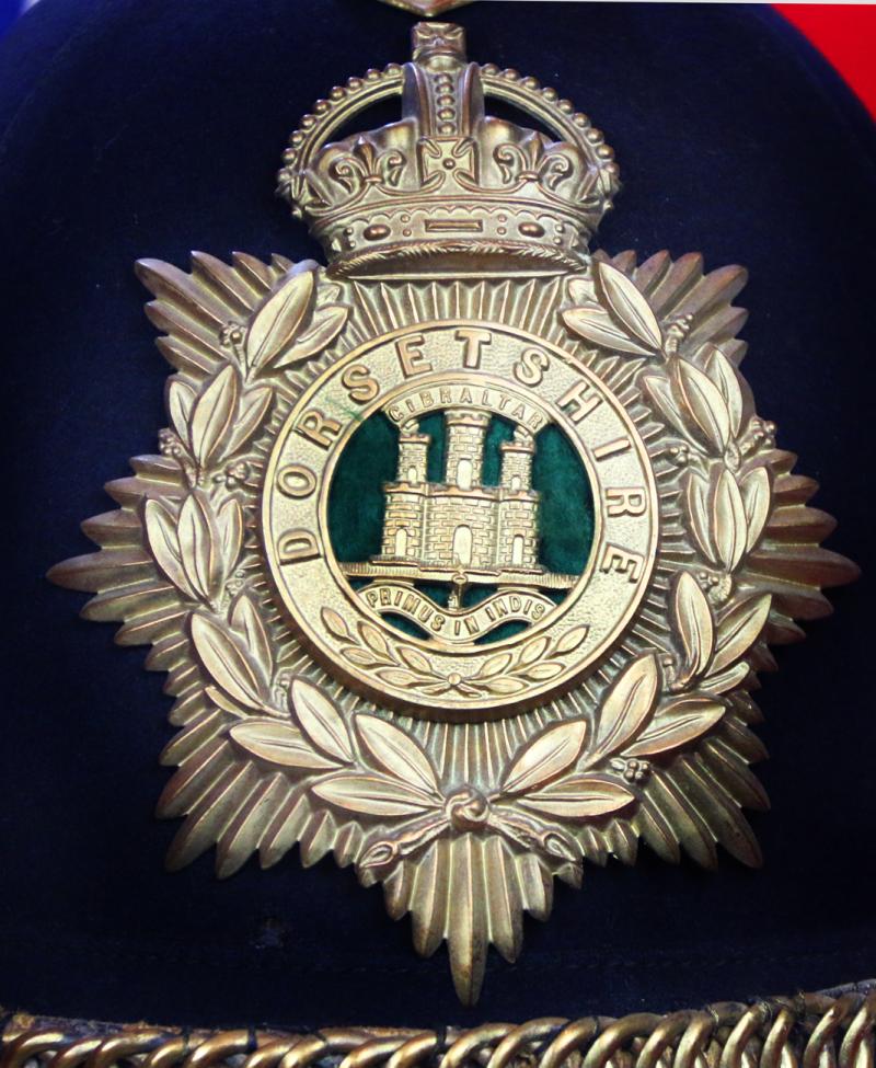 A Superb Antique Edwardian Service Helmet of The Dorsetshire Regiment. Blue Cloth with Gold Badge, Fittings, Spike, & Rose Head Curb Chain Mounts and Chin Chain