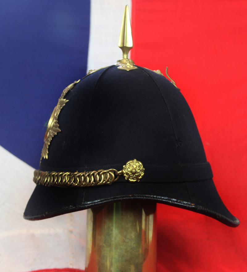A Superb Antique Edwardian Service Helmet of The Dorsetshire Regiment. Blue Cloth with Gold Badge, Fittings, Spike, & Rose Head Curb Chain Mounts and Chin Chain