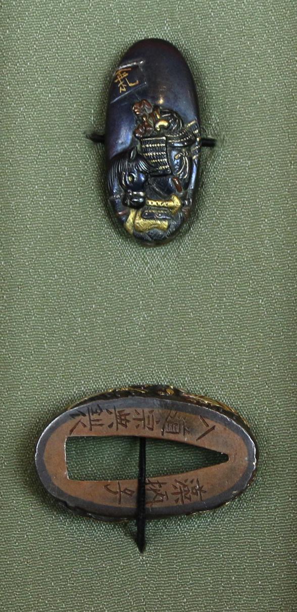 Fine Pair of Samurai Sword Mounts, A Fuchigashira In Pure Gold Onlay & Inlay On Shakudo, Soten School, Edo Period {1615-1868} Inscribed Sōheishi Nyūdō Sōten Sei. Taira Atsumori (1169-1184) Riding On Horseback Through Crashing Waves To Escape The Minamoto