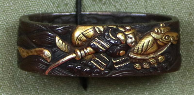 Fine Pair of Samurai Sword Mounts, A Fuchigashira In Pure Gold Onlay & Inlay On Shakudo, Soten School, Edo Period {1615-1868} Inscribed Sōheishi Nyūdō Sōten Sei. Taira Atsumori (1169-1184) Riding On Horseback Through Crashing Waves To Escape The Minamoto